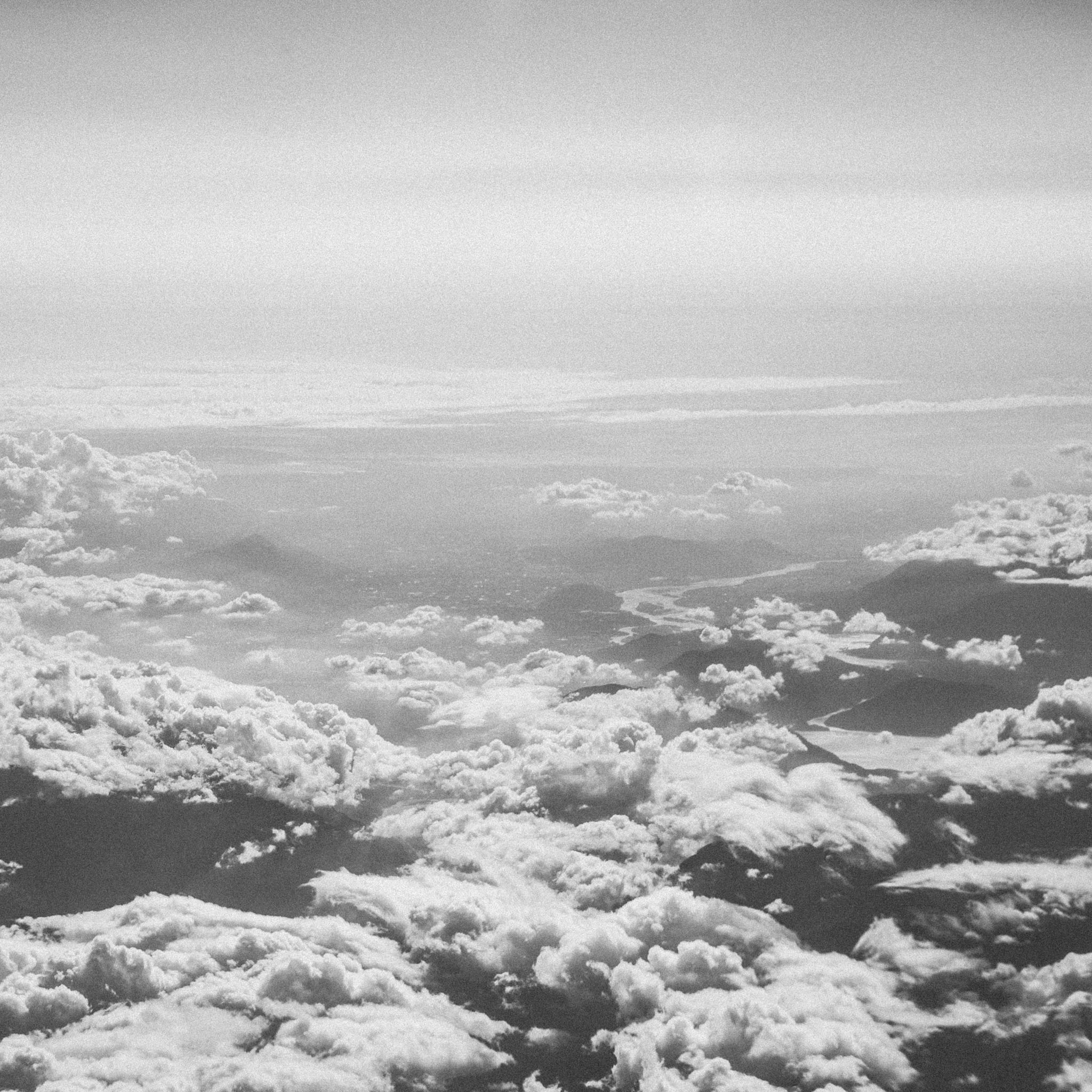 Aerial view of clouds stretching to the horizon in black and white