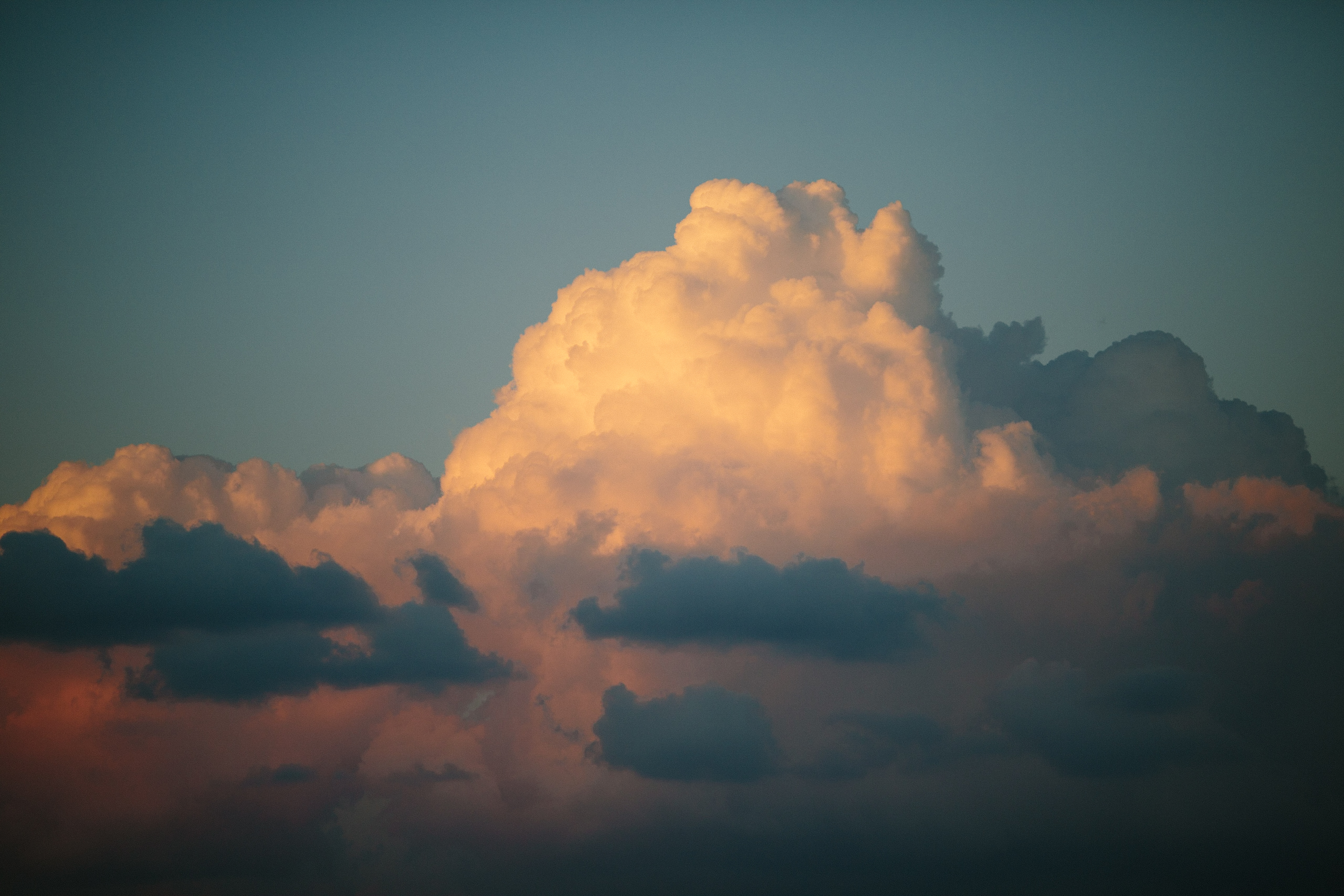 Towering cumulus cloud illuminated by warm golden light